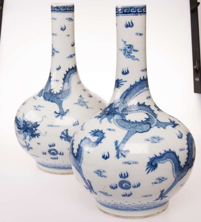 Two blue and white vases with design of dragons chasing pearls among clouds. These were award vases emperor Tonghzi awarded as a token of gratitude to subjects who proved they were an asset to the empire. They are apocryphally signed Kangxi on the