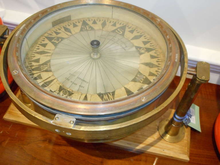 This is a rare dry compass made by Kelvin and Hughes, England, from the early 1900s, brass. It sits on a custom-made, gimbled teak and brass base and the base dimension is 18 inches W x 5 inches D.