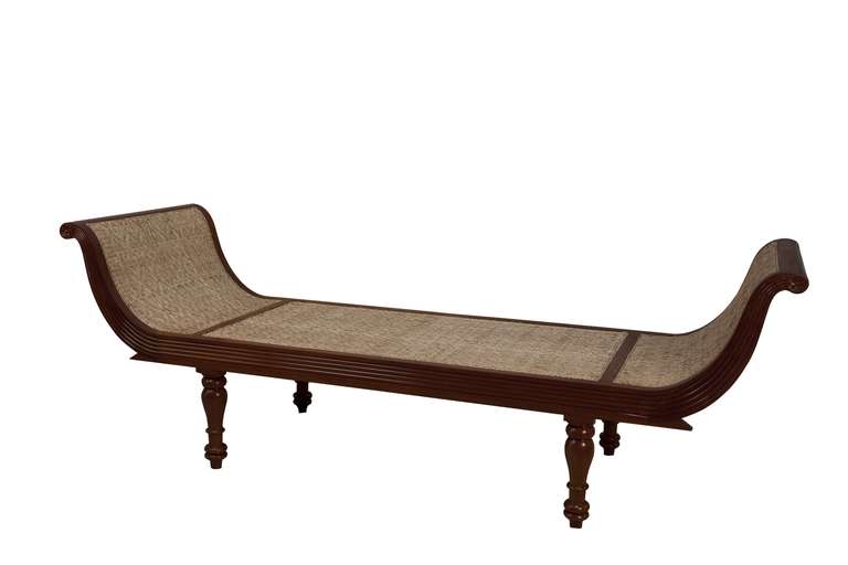 A Mid-century British Colonial mahogany daybed with reeded sides, intricate caning (replaced) and optional chenille cushion.