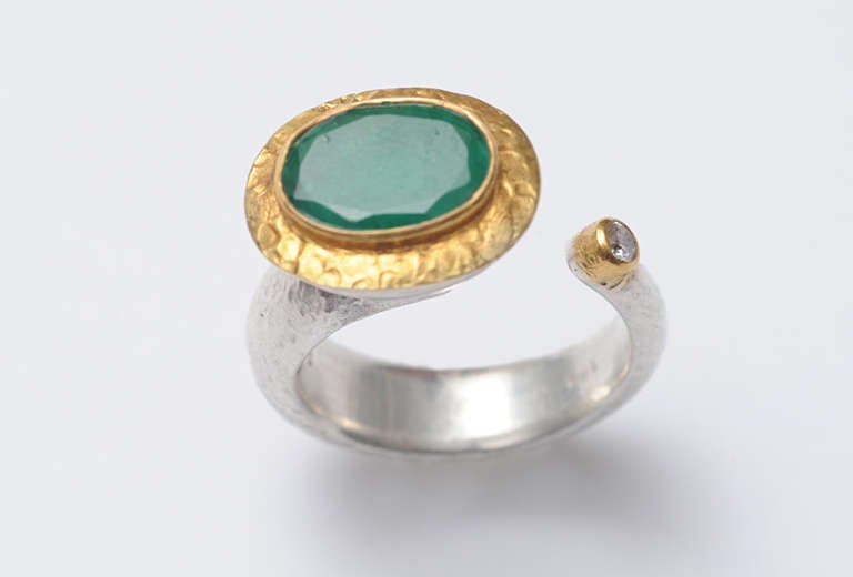 Une bague asymétrique inhabituelle construite en sterling martelé et en or 22K lesté (pas un vermeil) avec une grande émeraude facettée et un petit diamant sur le côté.  La taille de la bague est de 6 3/4.