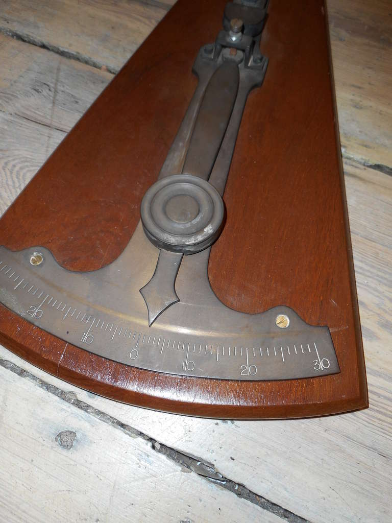 This is a rare American ship brass clinometer (used to measure degrees of healing on a ship) from the early 1900s, mounted on a teak board.

Shop located on Nantucket island.
Nautical artifacts and marine antiques.