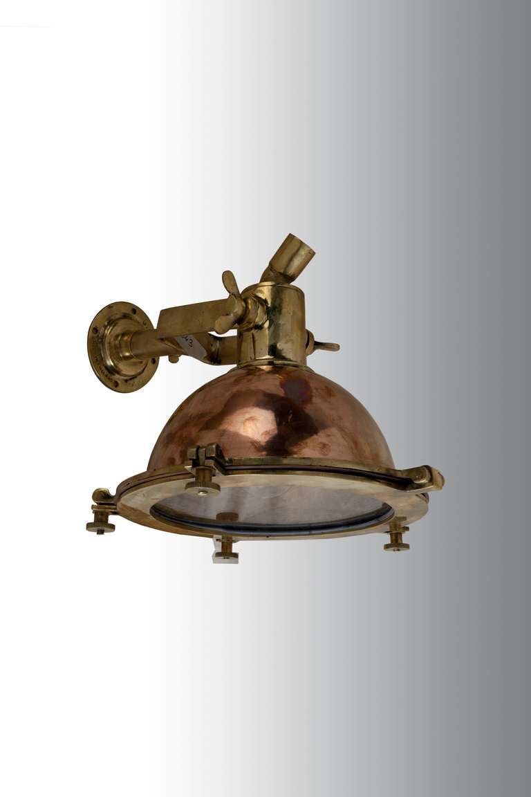 A Ship's deck or fox light made of copper and brass and can be used as a hanging pendant over an island or table, or as a wall sconce mounted and adjusted downward.  Takes a regular size light bulb and the face opens like a hinged porthole. 