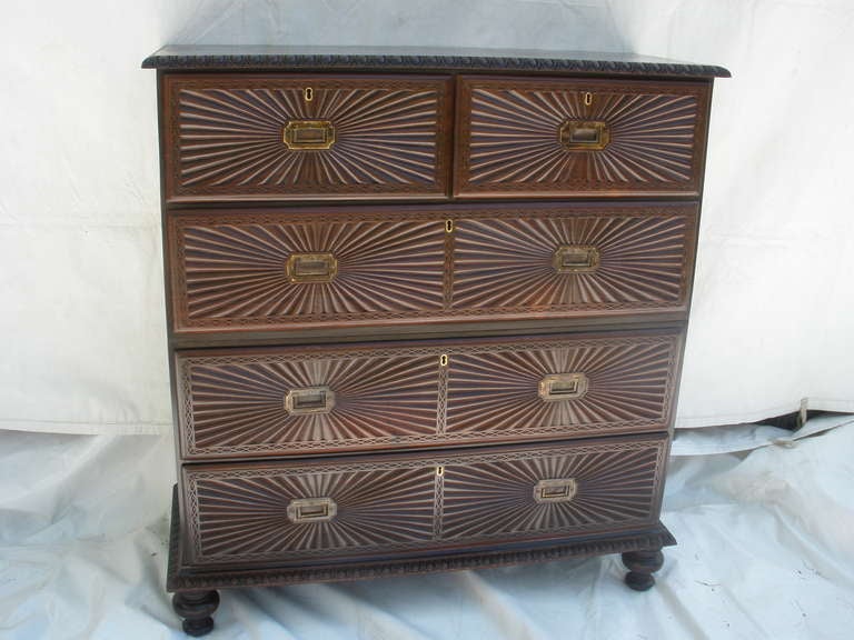 Late 19th century British Campaign rosewood chest of drawers.  Travels in two parts, brass handles on sides, and recessed brass drawer pulls.  Has an Anglo-Indian twist with the sunburst carved drawer fronts and gadrooned edge along the top and base