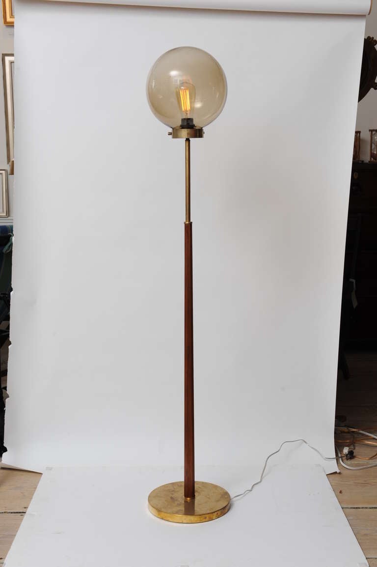 Deco period teak and brass floor lamp from a mid-century cruise ship.  Beveled teak base, brass stem and base and smoked glass ball shade (great with an Edison bulb); and takes a regular size bulb.  Rewired for American use, originally European