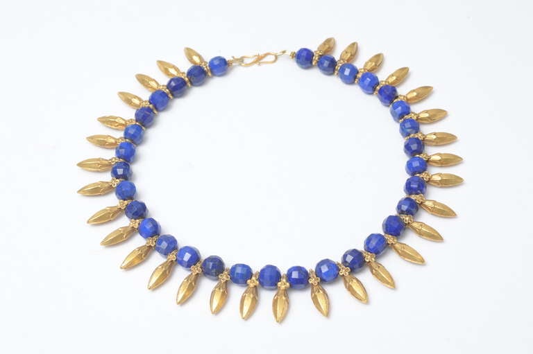 Old 22K gold spear-shaped pendants with fine detailing paired with exquisite peacock blue lapis lazuli.  Adding to the uniqueness, these lapis beads are faceted and the gold pendants have beautiful detailing.

Fine Indian jewelry location on