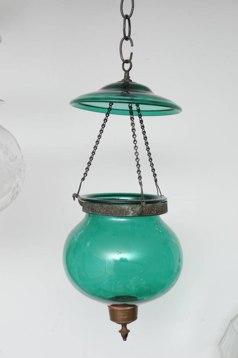 Late 19th century rare green hall lantern in globe form with smoke cap and brass hardware and handblown. Originally used with candles, these can easily be electrified without altering the integrity of the piece. See the sample photo of the type of