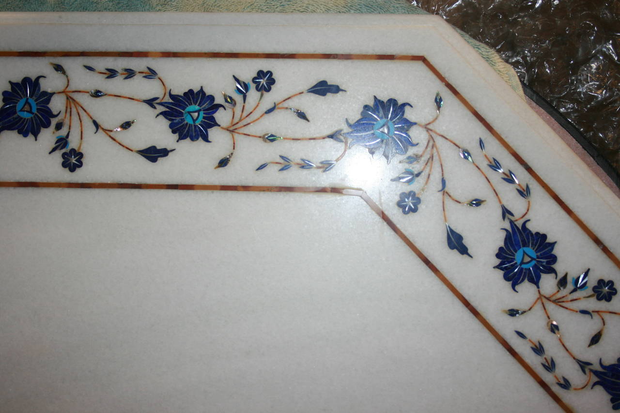 Intricate and beautiful inlay of lapis lazuli, mother-of-pearl, turquoise and carnelian in a white marble octagonal table top on an iron base. In the Agra style. Great to use inside or out. This is incredibly intricate and fine inlay work as opposed
