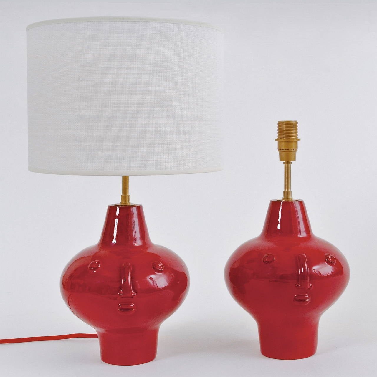 A small pair of ceramic lamp-stands, earthenware glazed in a deep  and shiny red glaze. 
All the pieces modeled and signed by the artists are unique. 

* The dimensions approx. are for the ceramic piece only : without the lamp-shade and without