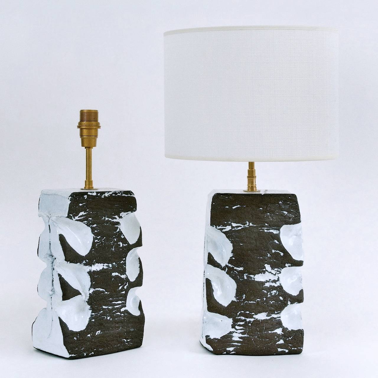 Hand-modeled twins lamp-bases, stoneware partially glazed in a shiny pure white on a matt and textured brown base. 

The two pieces are signed on the bottom with the ceramicist stamps.

Dimensions approx. are for the pottery pieces only :