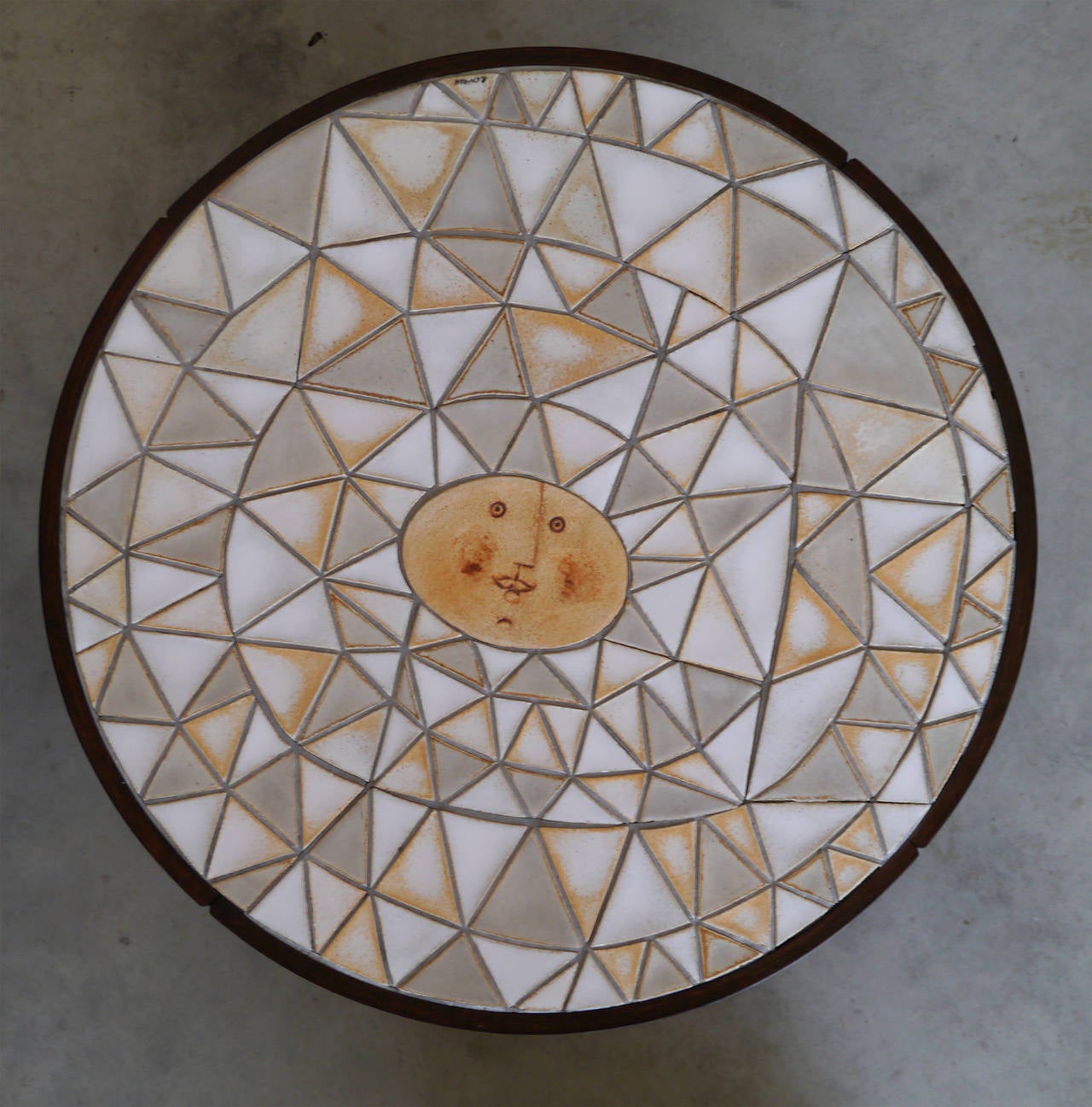 The top table consists in triangular sandstone parts forming a patchwork in various shades of matt and shiny glazes and forming a sun which is probably the most iconic subject of Capron's achievements.

It wears the Artist's signature.

We offer