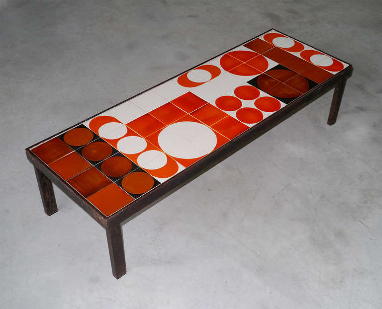 Large and massive coffee table with ceramic tiles in various shades from burnt to vivid orange, artistically arranged to give a beautiful rythmic pattern.

A nice cooperative work between Gilbert Portanier and Roger Capron.

It is signed on one