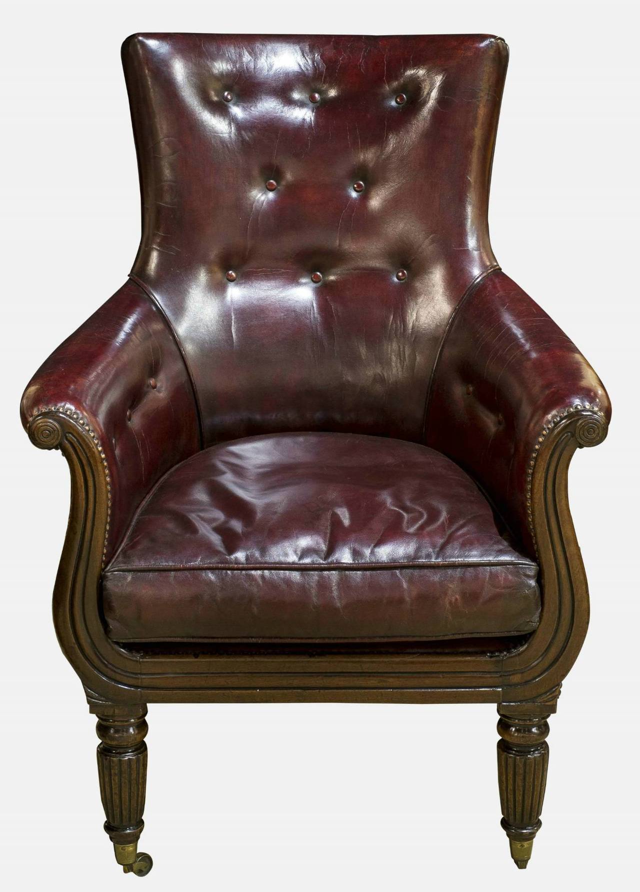 A Regency mahogany library chair upholstered in burgundy red leather in the manner of George Smith.