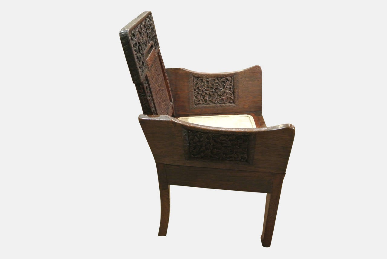 A pair of exquisitely carved Anglo-Indian teak armchairs that had been commissioned for a Covent Garden tea house. The seat having been reupholstered in a contemporary fabric.