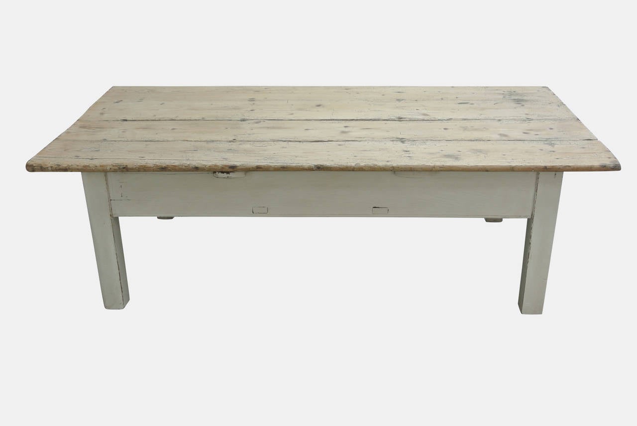 An early 19th century painted rustic pine farmhouse coffee table with central drawer.