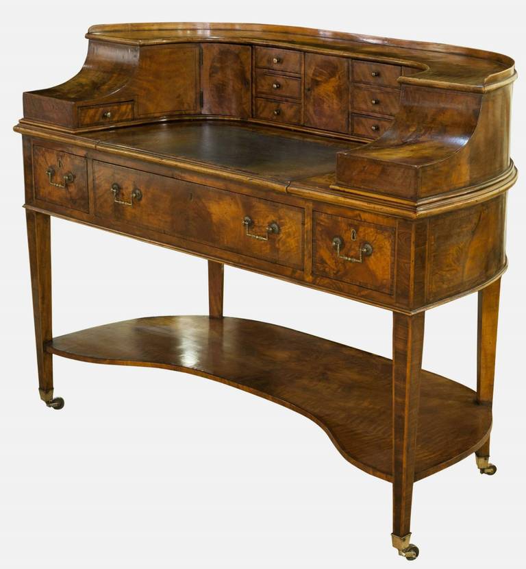 A beautifully restored George III satinwood and mahogany crossbanded Carlton House Desk, beautifully figured and with rich color. The swept super structure with an arrangement of cupboards and drawers with sliding inset with original tooled leather