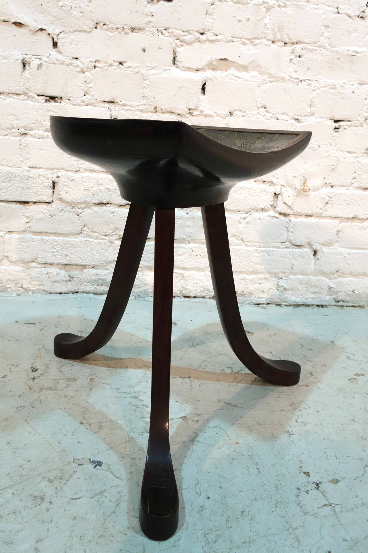 Three-legged stool in wood and leather. 
Design and manufacturing attributed to Leonard F. Wyburd for Liberty & Co.
Wooden structure in solid state.
Surface shows signs of wear consistant with the age (see pictures).
This three-legged stool was