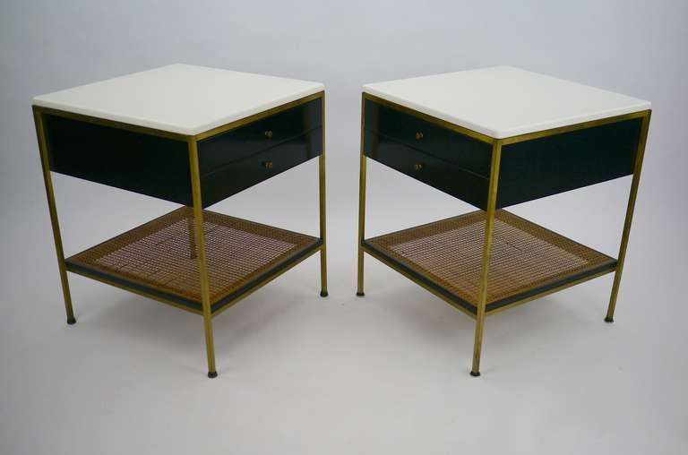 Paul McCobb nightstands with vitrolite tops, brass frames and caned shelves.