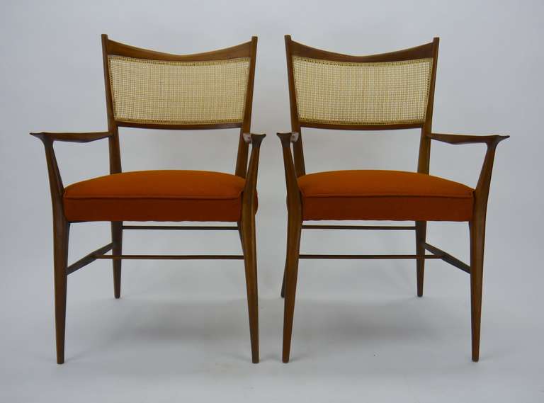 Set of 12 Paul McCobb Irwin collection dining chairs with sculpted mahogany frames and caned backs.10 side chairs, 2 armchairs. Chairs are back from refinishing, we had them done in a dark semi opaque walnut stain, all of the caning has been