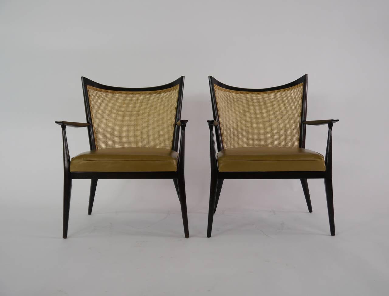 Elegant pair of lounge chairs in cane and leather by Paul McCobb for Directional. Recent reupholstery in leather, re caned and refinished.