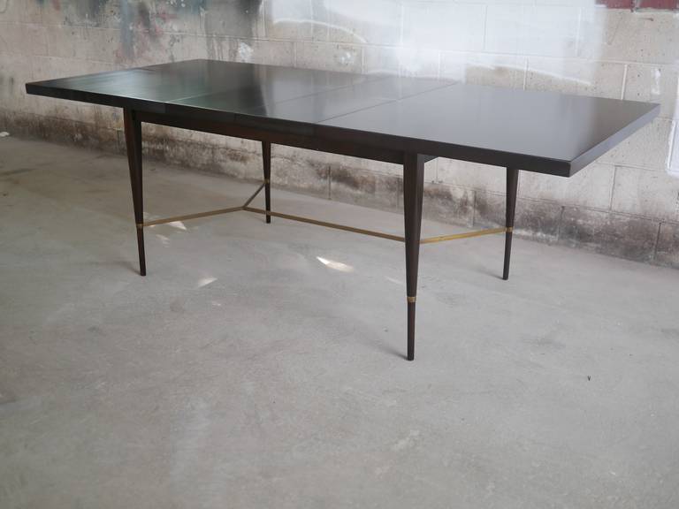 Mahogany and brass dining table designed by Paul McCobb. Two 12