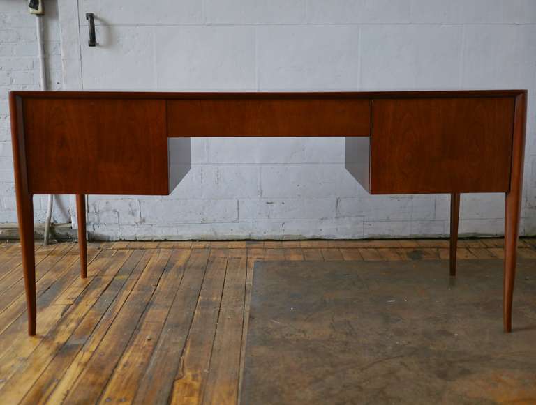 Simple and elegant desk in Walnut by T.H. Robsjohn Gibbings for Widdicomb. This design features two sizable drawers and a pencil drawer in the middle. Note the last two photographs are the finished back.