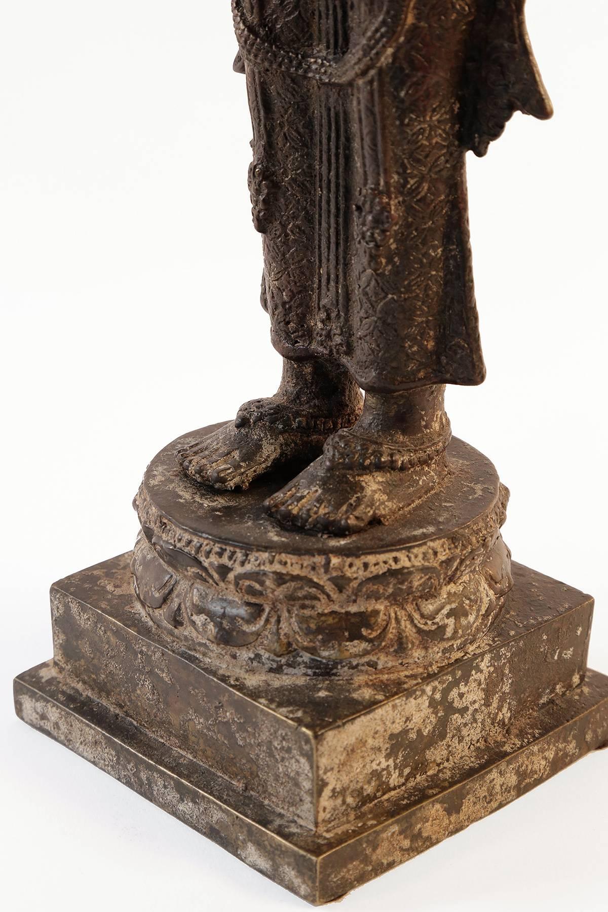 15th/16thc. Javanese Bronze Rice Goddess

Known as Dewi Sri, the goddess of rice and fertility, the standing figure dressed in highly embellished jeweled sarong and headdress, with bejeweled upper torso, holding a rice flower and wearing a serene