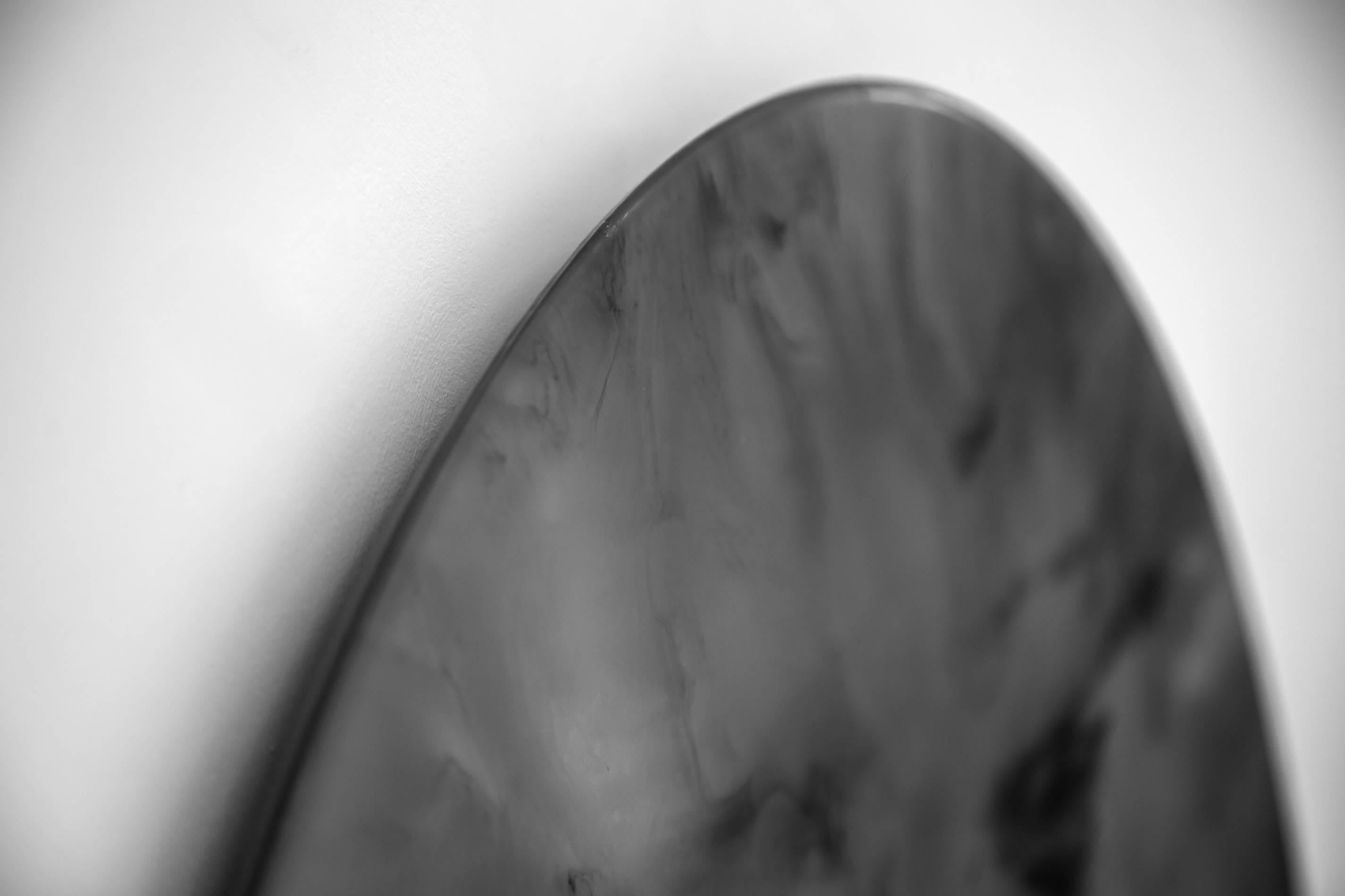 The Ether mirror is a subtly reflective piece with turbulent black clouds across its matt surface. While read first as an artwork and conversation piece it offers a dual purpose for an interior scheme by providing an understated reflection of