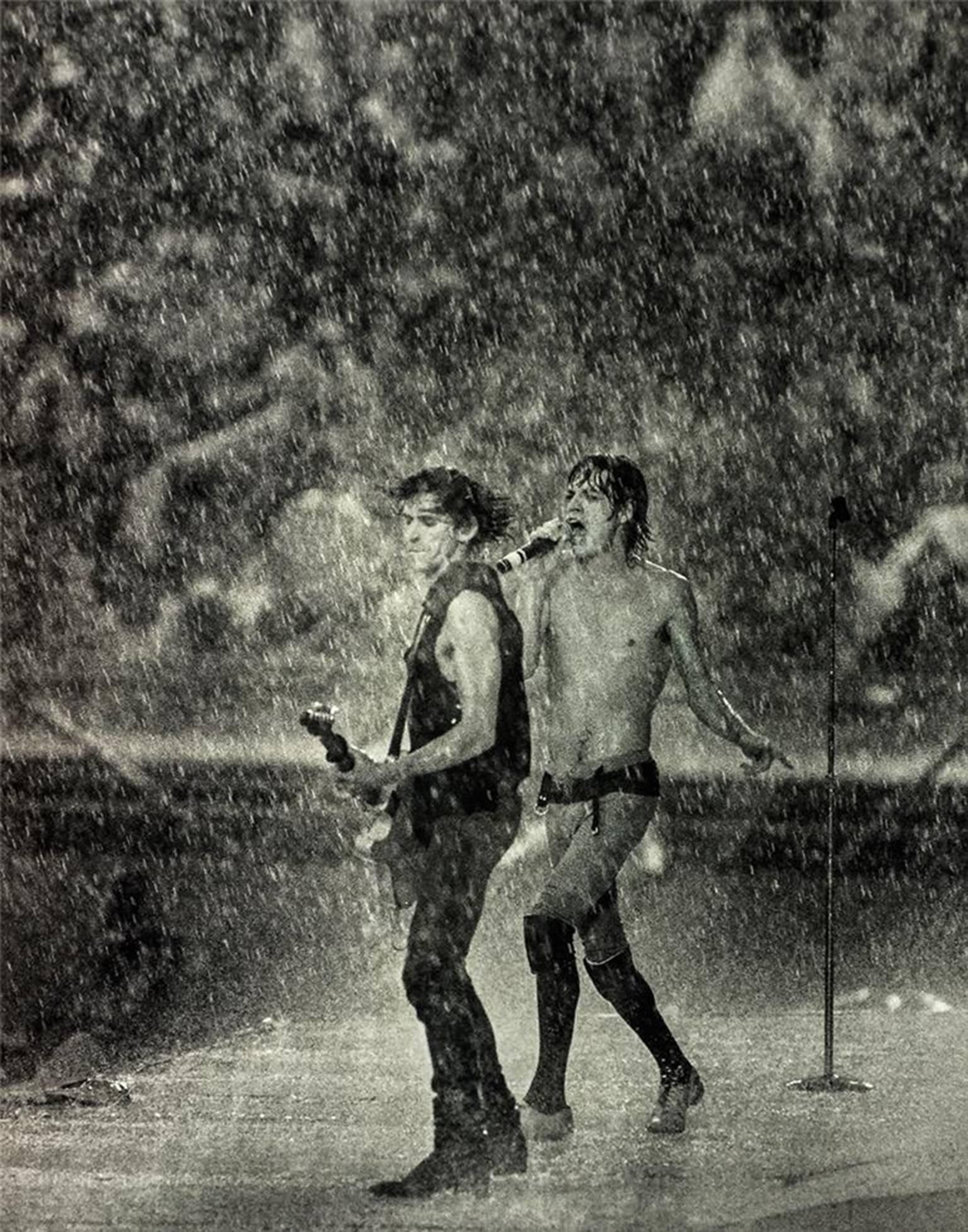 Jay Dickman Black and White Photograph - Mick Jagger & Keith Richards in Dallas Rainstorm Performing, 1981