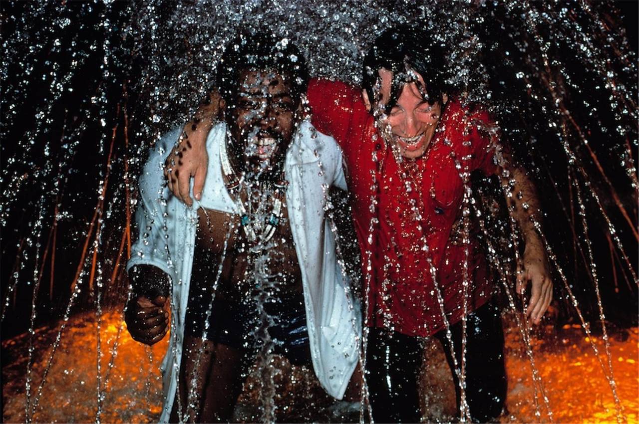 Lynn Goldsmith Color Photograph - Bruce & Clarence in a fountain