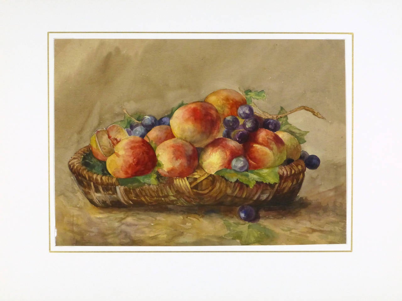 Richly hued French still-life watercolor of a basket of ripe and appetizing peaches and juicy grapes, circa 1920. Artist unknown. 

Original one-of-a-kind vintage work of art on paper displayed on a white mat with a gold border. Mat fits a