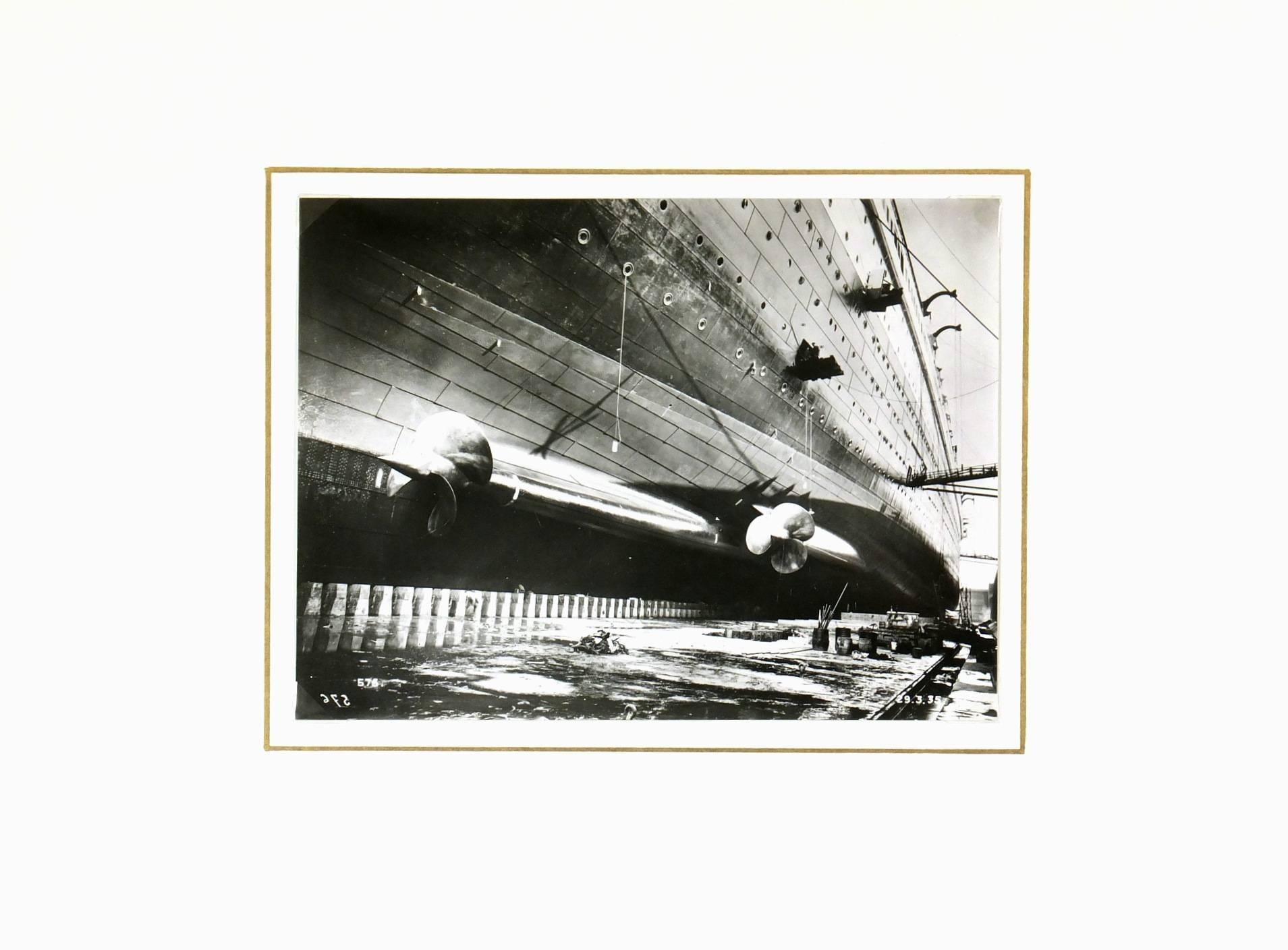 Fabulous industrial French black and white photograph of the luxury steamer "Le Normandie" in 1935. 

Original one-of-a-kind artwork on paper displayed on a white mat with a gold border. Mat fits a standard-size frame. Archival plastic