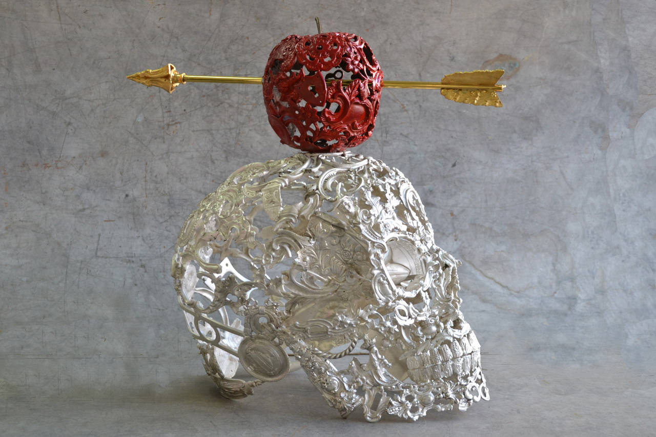 Bellino’s Sucessful skull is a unique contemporary bronze sculpture representing a red apple pierce with a gold arrow above a white skull made of antique bronze ornaments that are welded together in a meticulous fashion. 
With heavy “Renaissance”