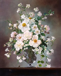 Abeilles parmi des anémones blanches, des roses et des freesias dans un vase en verre