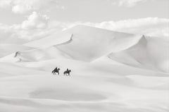 Deux cavaliers traversant des dunes de sable blanc à perte de vue