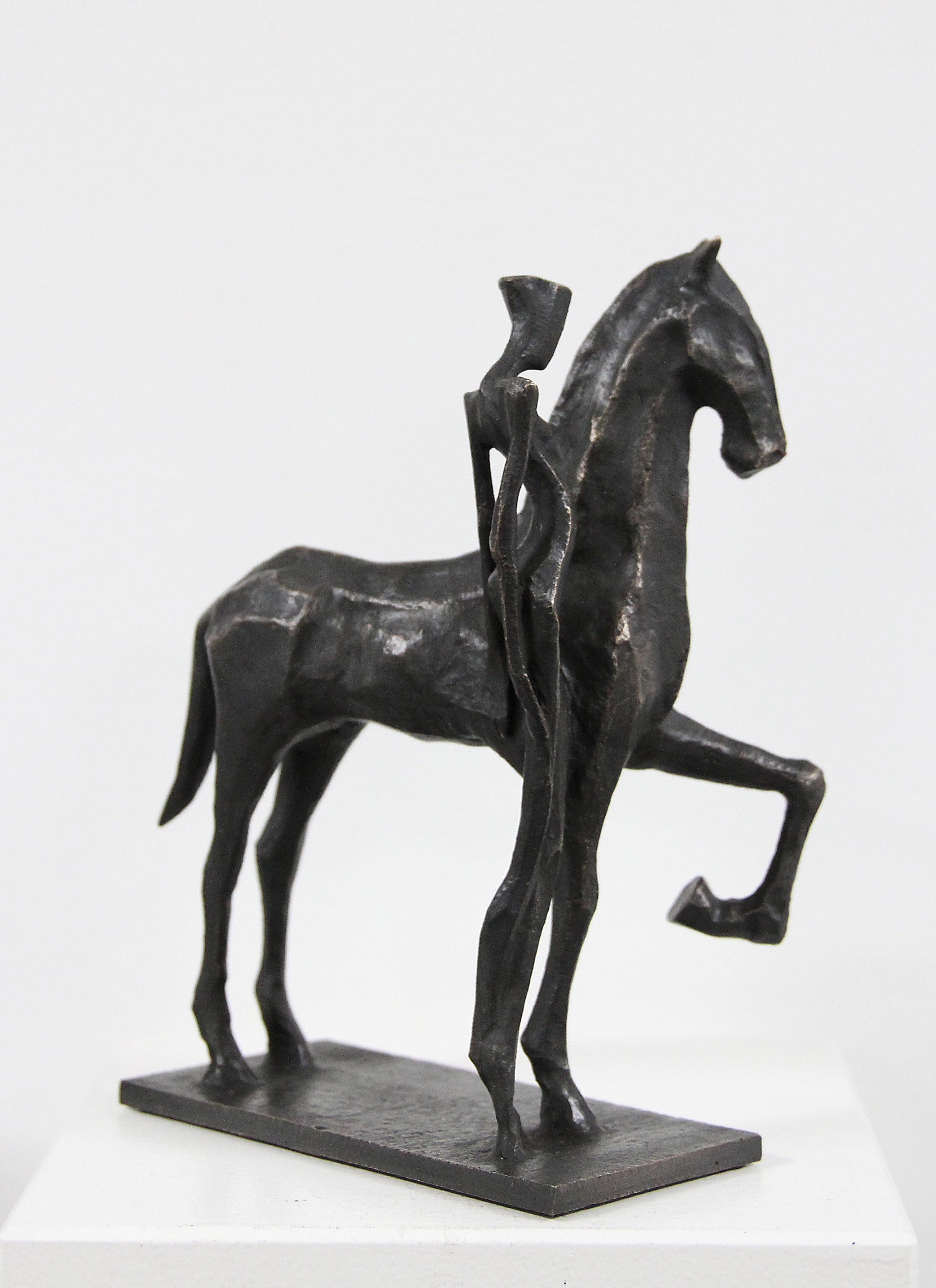 Lisa con Cavallo is an elegant figurative bronze sculpture by Nando Kallweit. It has a powerful harmony of strength and grace. The horse emerges with a rhythmic, elongated presence, one foreleg lifted in a gesture of quiet anticipation. This