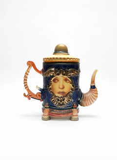 Visage sur une grande théière bleue et dorée