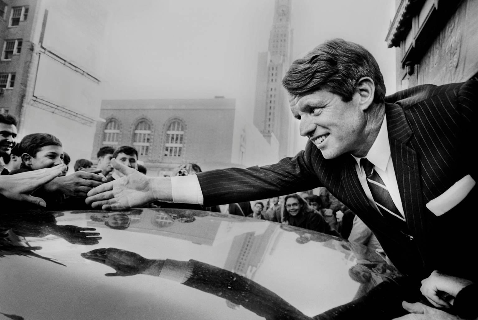Jean-Pierre Laffont Black and White Photograph - Bob Kennedy reaching hand over car, Brooklyn, New York 