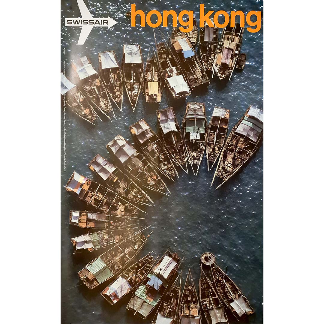 This original 1971 Swissair travel poster features an aerial photograph of Hong Kong by Georg Gerster, with graphic design by Emil Schulthess and Hans Frei. Printed in offset in Switzerland, it belongs to the celebrated campaign through which