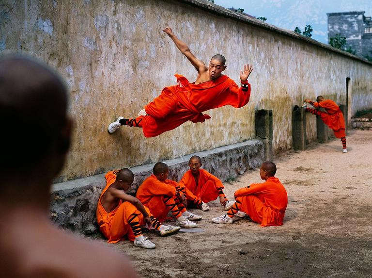 Steve McCurry Color Photograph - Monk Running on Wall