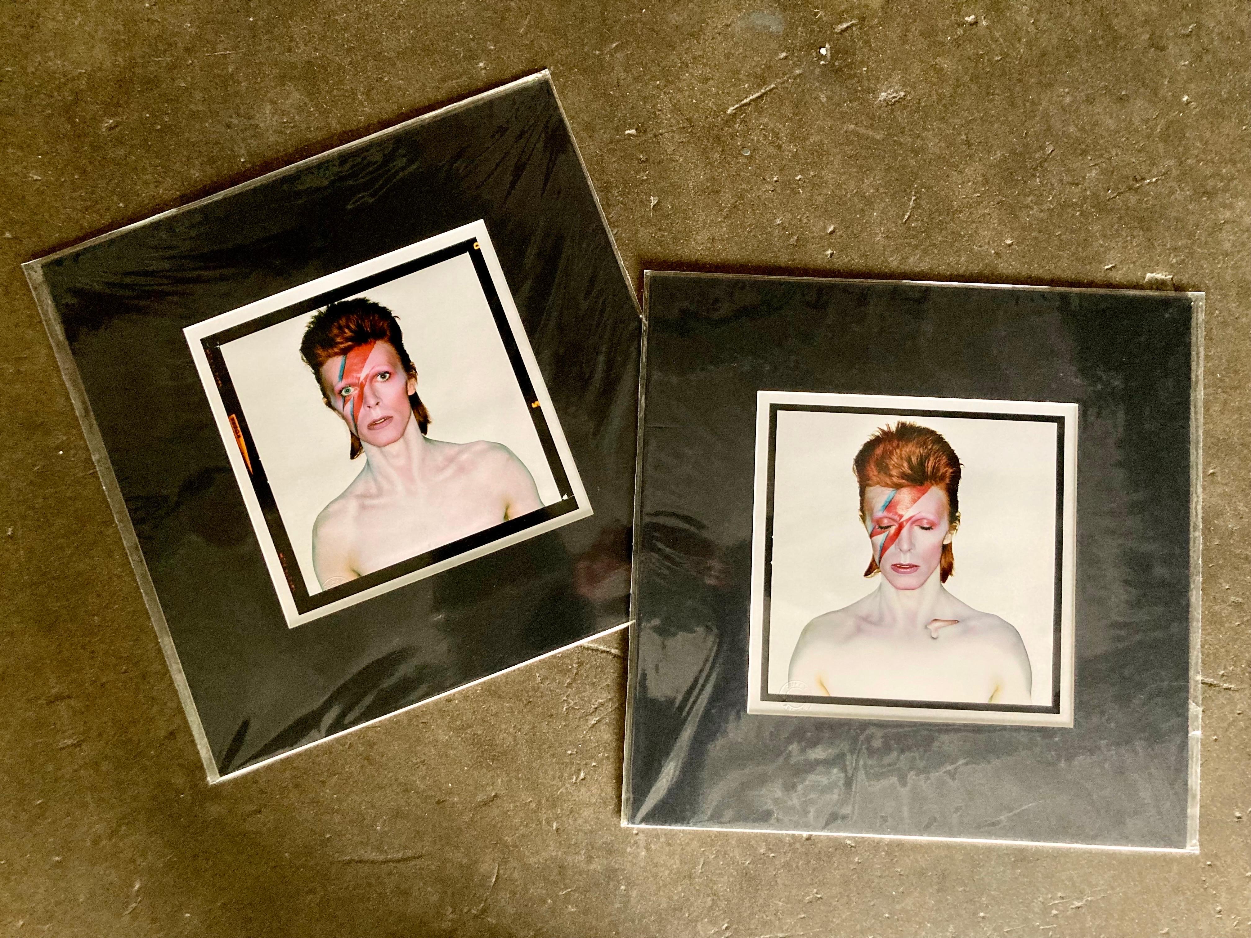 Lot de 2 tirages, tous deux pré-matés avec des passe-partout noirs. David Bowie par Brian Duffy lors des séances de création de la pochette de l'album Aladdin Sane en 1973. L'un des tirages est la couverture originale, le second est la version 