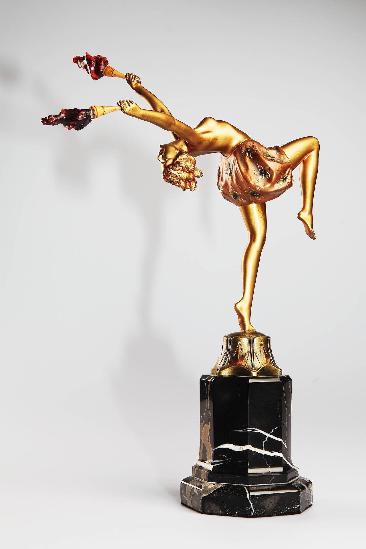 Art-Deco-Bronze mit Kaltbemalung auf gestuftem schwarzem Marmorsockel, um 1920. Von Johann Philipp Ferdinand Preiss ( Deutschland 1882-1943 ). 
Modellnummer: 1084, signiert: F Preiss. Junge Frau, die auf einem Bein balanciert, den Rücken gekrümmt,