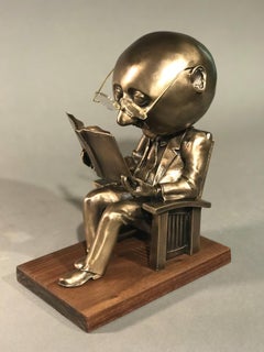 The Reader (small), gold bronze sculpture, reading book, glasses, Rodger Jacobsen
