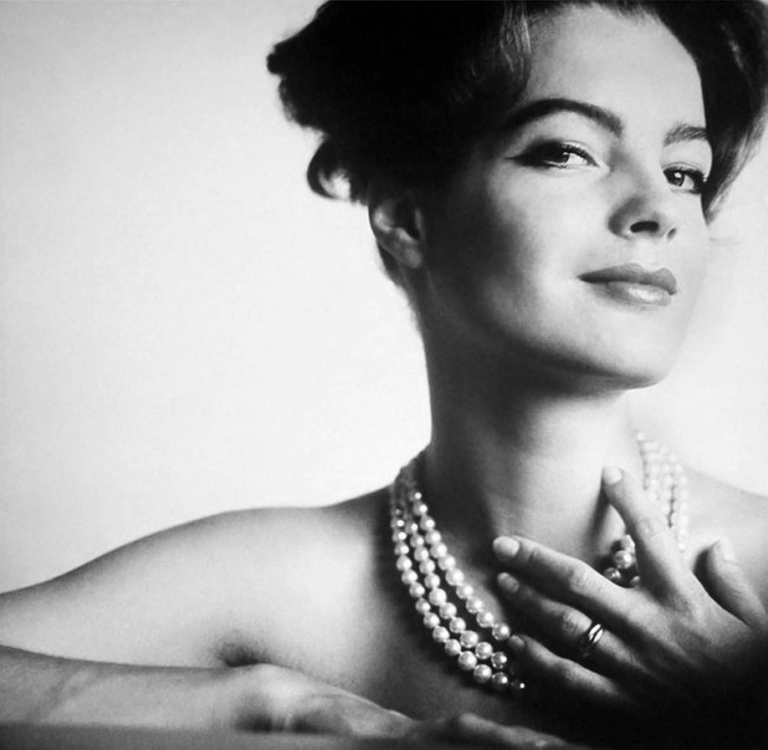 Black and White Photograph Douglas Kirkland - Portrait de Romy Schneider, presque nue seulement avec un collier de perles la touchant