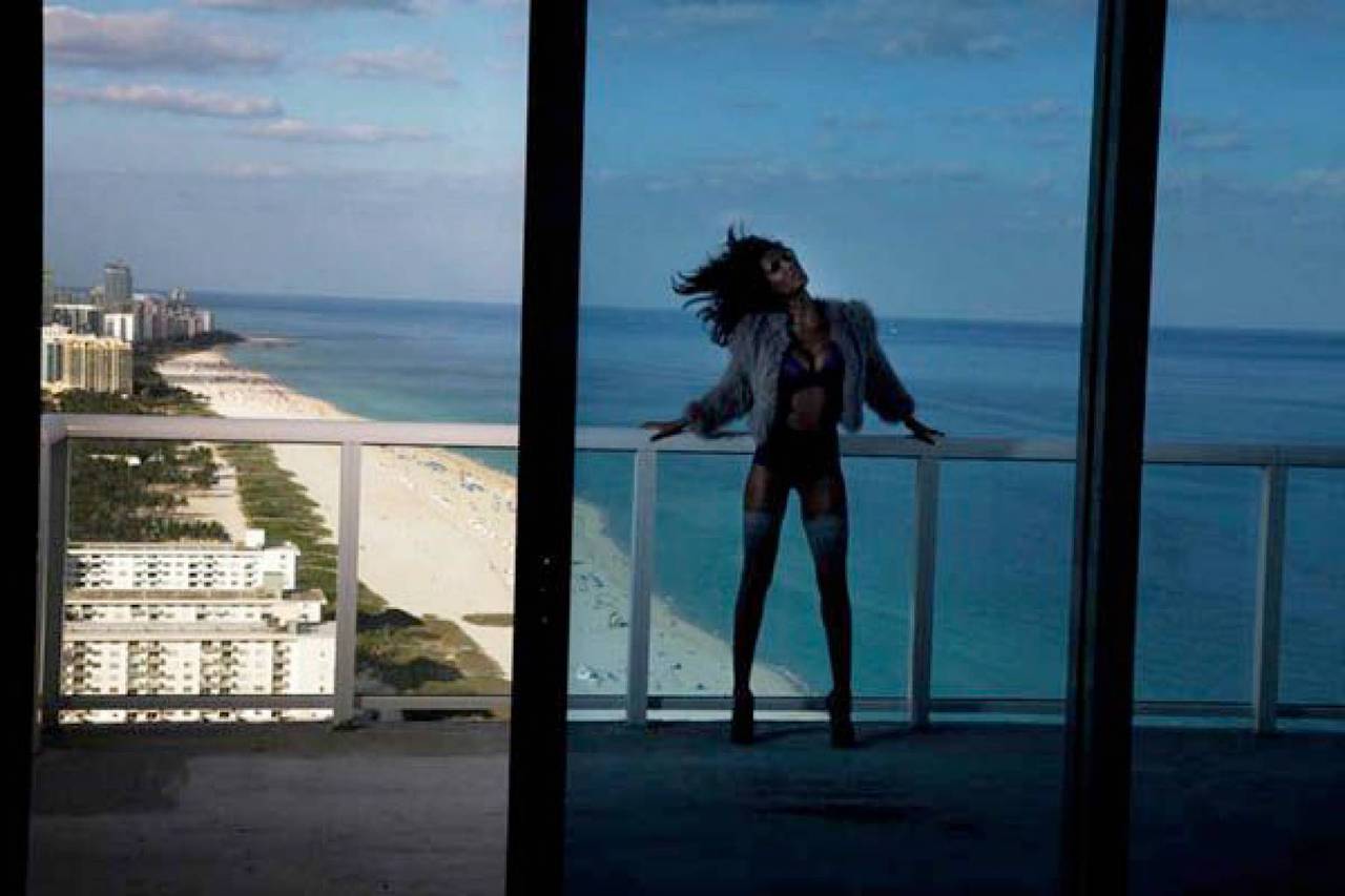 Recap- Woman in black lingerie with a jacket, standing on the balcony at the sea