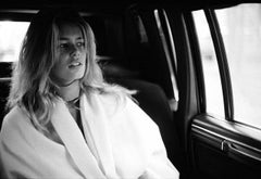 Claudia Schiffer - the young supermodel sitting in a car wearing a white coat