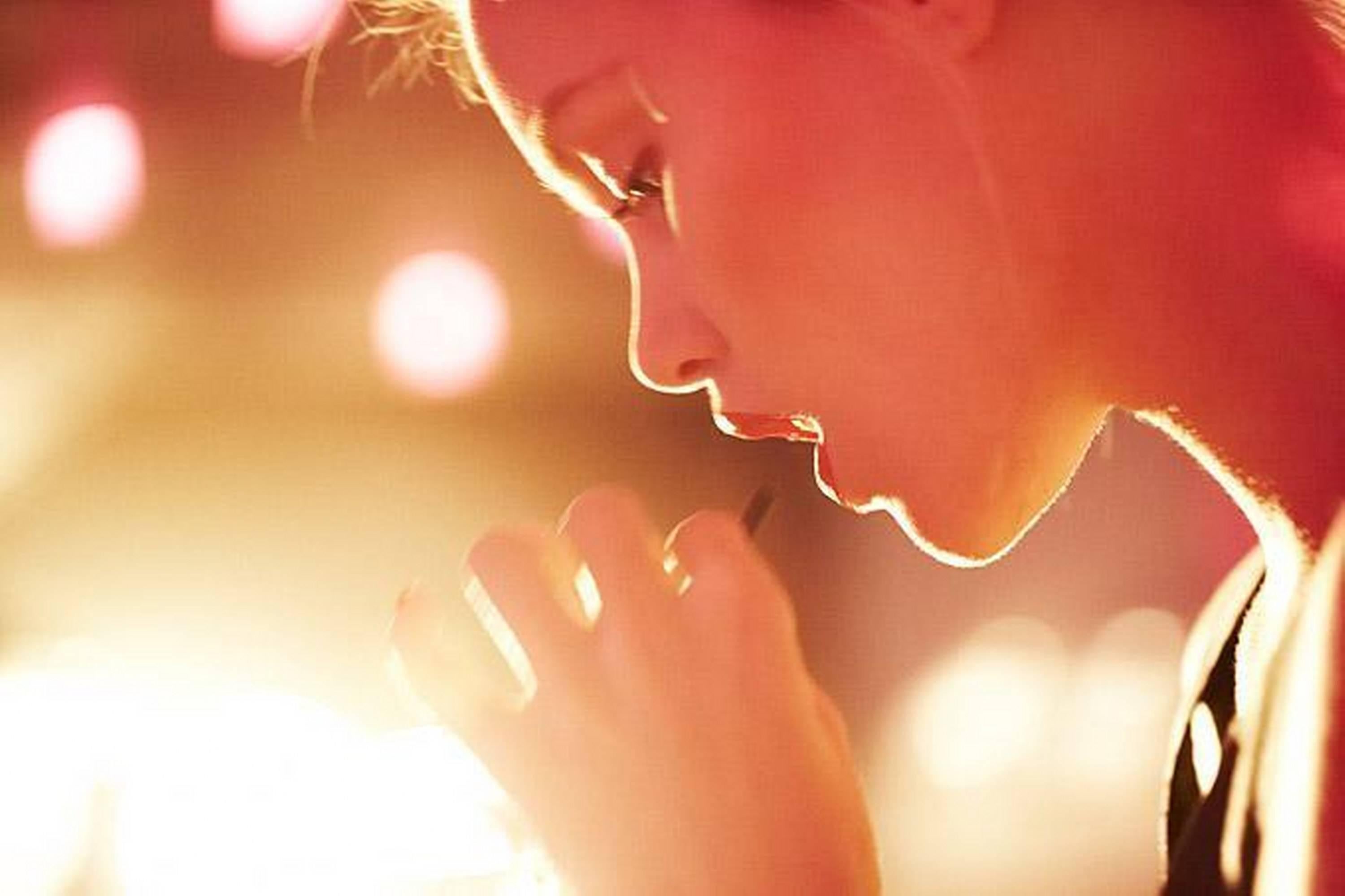 Guy Aroch Color Photograph - Untitled Face of blonde woman in sunlight drinking from straw