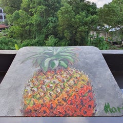 Naturaleza muerta con una piña entera sobre un fondo gris con textura