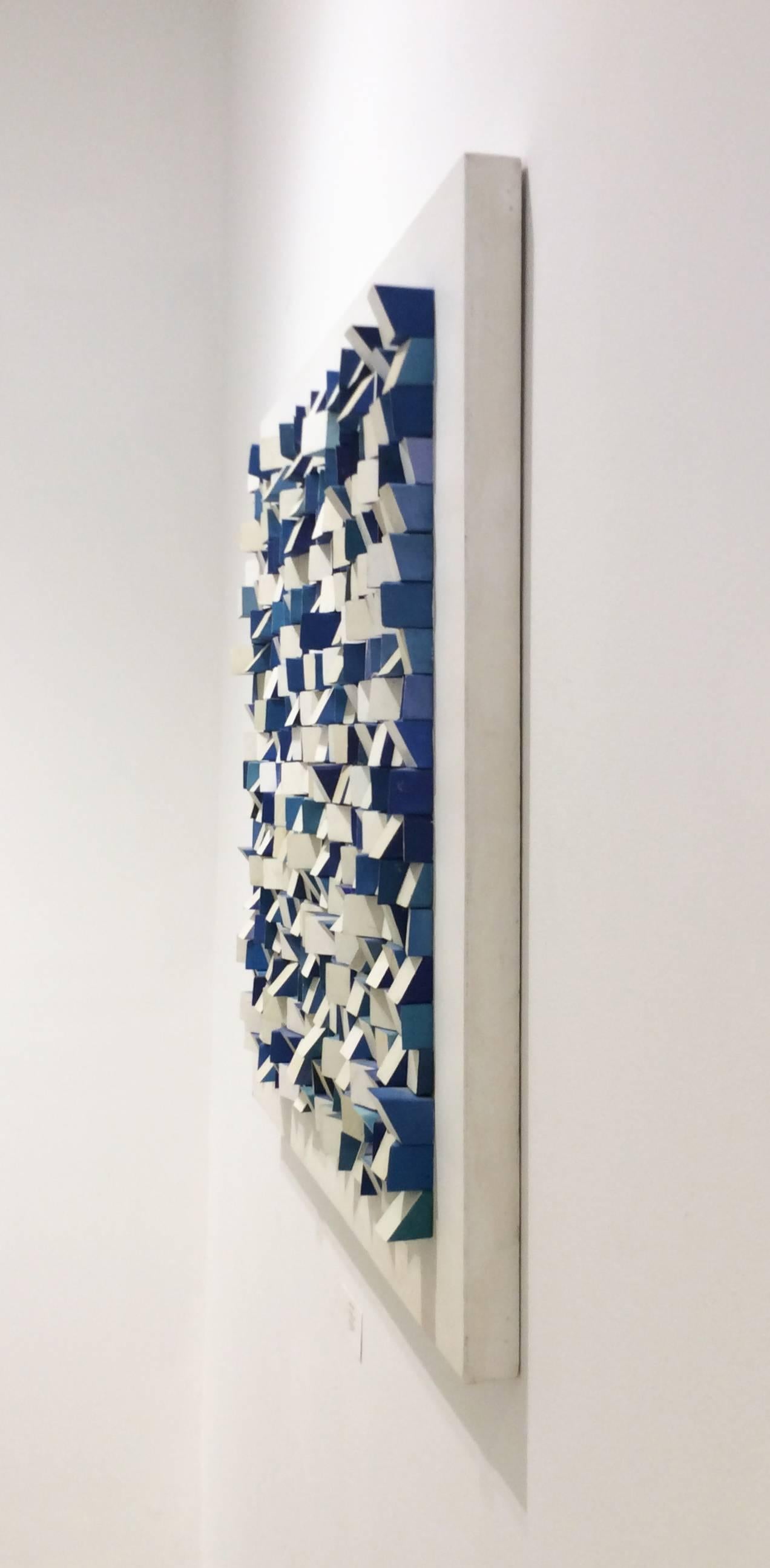 36 x 36  x 3.5 inches

Square wood blocks carefully carved and hand painted in acrylic in off-white and assorted blue hues adhered to a white painted wood panel that measures 36 x 36 inches. 

This abstract, modern three-dimensional wall sculpture