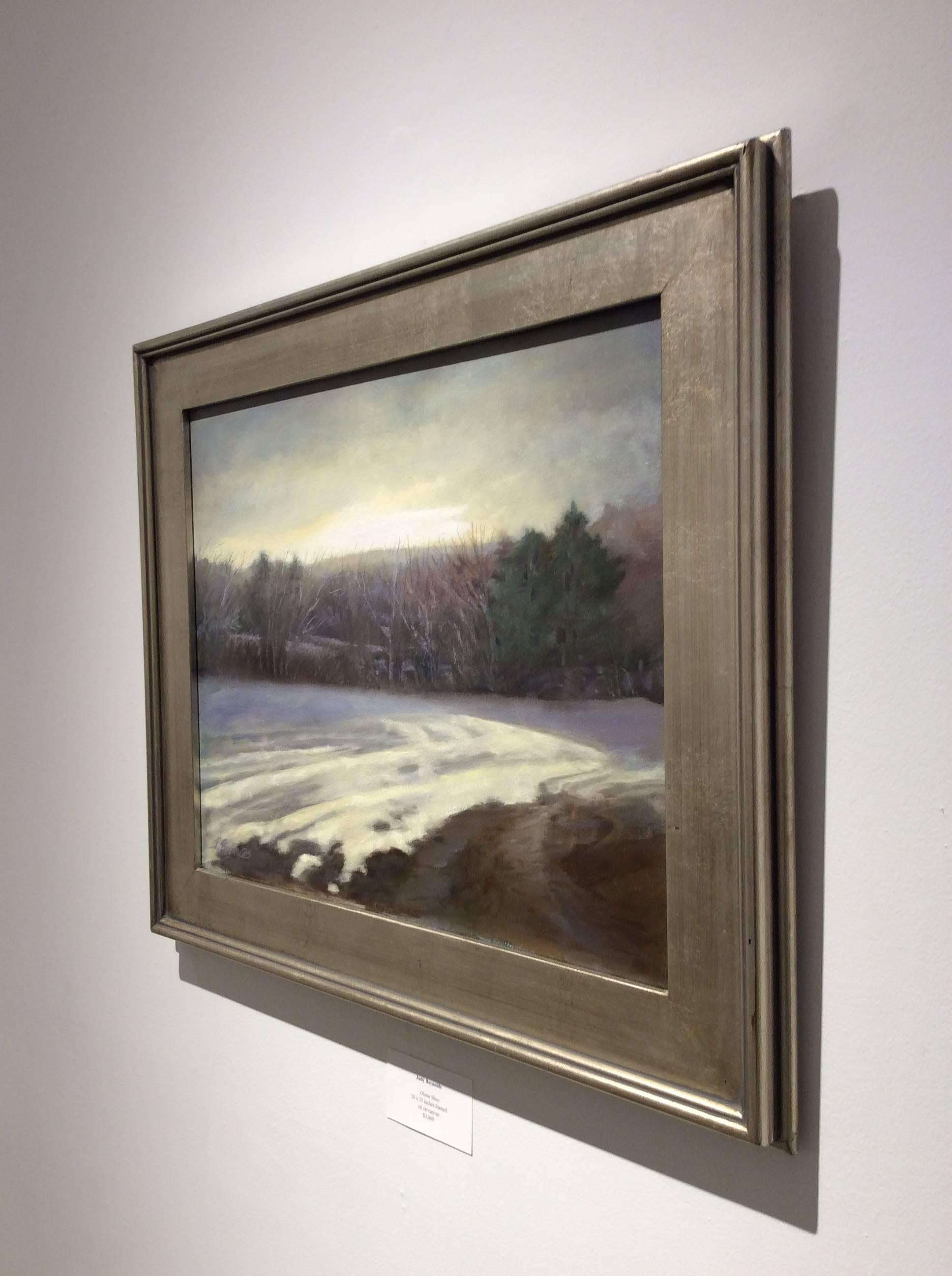 This oil on canvas en plein air landscape painting was painted by Hudson Valley based artist, Judy Reynolds. The composition features a barren corn field in winter layered with creamy white snow. With a palette of delicate yellow, blue, grey, white,