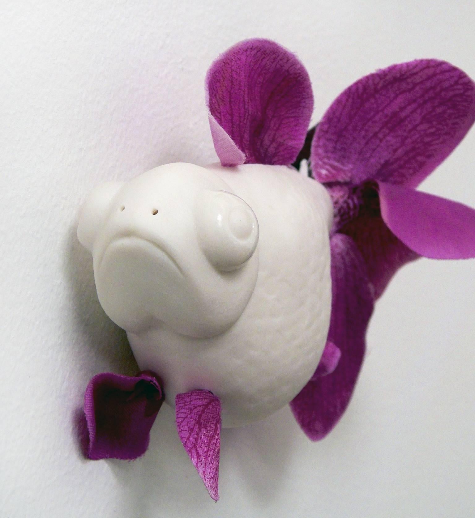 This little fish by Bethany Krull, is made of white porcelain and fuchsia colored, artificial orchids. If you've ever looked at a fan tailed fish and marveled at the flamboyant tail you understand the inspiration for this playful portrayal. ;Prize